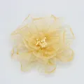 Vista macro del fermaglio a fiore in organza con petali color oro champagne e stami bianchi - Giallo Pallido