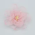 Dettaglio ravvicinato di un fermaglio a fiore in organza rosa con petali e stami perlati - Rosa