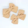 Detailed macro view of handmade linen fabric bow knot accessories in soft beige - Khaki