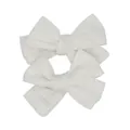 Detailed macro view of two handmade white fabric bow hair clips with textured linen weave - White