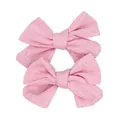 Detailed macro view of two pink linen fabric bow hair clips with natural texture - Pink