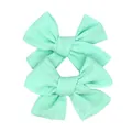 Close-up of a pair of mint green bow hair clips showing textured cotton-linen fabric - Light Green