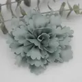 Close-up of sage green satin fabric flower with pleated petals for DIY hat and dress decor - Fruit Green