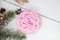 Detailed top view of a pink fabric rose hair clip on a white wooden background - Flat Pad / Pink