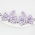 Close-up of handmade purple gingham bow hair clips with soft fabric wrapped metal base - Purple