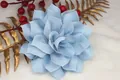 Broche de flor artesanal azul claro con pétalos de malla sobre fondo blanco suave - Azul