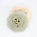 Détail d'un chouchou floral en mousseline avec pétales délicats et ruban de satin crème - Vert Cyan