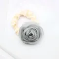 Close-up of elegant cream satin hair scrunchie with a large 3D silver-grey fabric rose decoration - Gray