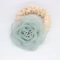 Détail du chouchou fleur en organza vert clair avec élastique en tissu plissé beige crème - Aqua