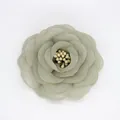Vista dall'alto di una spilla a forma di camelia in tessuto grigio-verde con petali beige - Base piatta / Verde Grigio