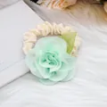 Detail eines floralen Chiffon-Haargummis mit hellgrünen Blütenblättern und Blättern - Grün