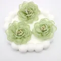 Macro detail of three 3D green organza fabric camellia flowers with bead centers - Flat Pad / Green