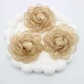 Dettaglio di fiori di camelia fatti a mano in organza champagne con perline centrali - Base piatta / Cachi