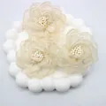Macro di tre fiori di camelia in organza color crema con delicati centri di perline - Base piatta / Beige