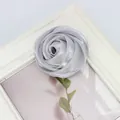 Nahaufnahme einer silbergrauen Satin-Rosenknospe mit Seidenstoffschichten und Details - Grau