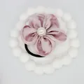 Detail of pink satin flower hair tie with a central pearl and black elastic band - Lavender