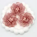 Detailed macro view of 3D pink organza camellia fabric flowers with beaded center - Flat Pad / Dusty Rose