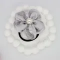 Detailed close-up of a silver floral hair scrunchie with a central white pearl detail - Gray