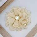 Detailed macro view of champagne peony fabric flower with golden edges and pearl center - Khaki