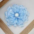 Detailed macro view of light blue fabric peony with layered petals and a pearl center - Blue
