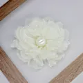 Dettaglio di una spilla a forma di peonia in tessuto crema a strati con perla e raso - Stile a Fondo Piatto / Beige