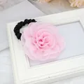 Chouchou à rose en mousseline rose avec élastique noir sur fond blanc élégant - Rose