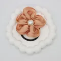 Elastic peach chiffon flower hair tie with pearl center on decorative white plate - Muted Orange