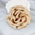 Elegant champagne satin fabric rose brooch pin in a decorative white ceramic dish - Khaki