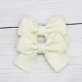 Set of two cream white bow hair clips for girls with textured fabric on white wood background - Beige