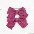 Pair of cute dark pink glitter fabric bow hair clips for little girls on white wood - Purple