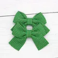 Set of two green and white checkered bow hair clips for girls on a white wood background - Christmas Green
