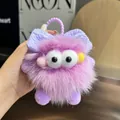 Detalle del llavero de monstruo de peluche morado con textura suave y un lazo - Púrpura