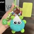 Detail of furry monster keychain with blue plush ball, green limbs and knit hat - Teal