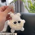 Close-up of fluffy white plush monster keychain with knit hat and sunglasses - Cream