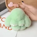 Close-up of fluffy light green rabbit keychain with soft faux fur and gold metal ring - Fairy Green