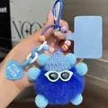 Detailed shot of a blue plush keychain with knit hat, sunglasses and heart charm - Blue