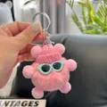 Detailed close-up of a pink plush bear keychain with a knit hat and tiny sunglasses - Light Pink