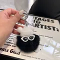 Detailed view of black plush soot sprite keychain with sunglasses and knit hat - Black