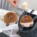 Detail of cute rabbit fur pom pom keychains hanging on a stylish black leather bag - Chestnut Style