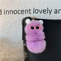 Dettaglio del portachiavi in peluche viola appeso a una borsa in pelle nera - Viola