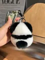 Close-up of fluffy panda keychain made of rabbit fur on car keys with a fashion background - Cute Little Panda Gives Away Horseshoe Buckles