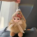 Detail van pluche pop sleutelhanger met bruine gebreide muts en pompon van vossenbont - Khaki