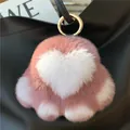 Macro shot of pink rabbit fur heart charm with paw details and gold spring clip - Dusty Pink