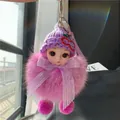 Detail van pluche sleutelhanger met grote ogen, roze bontbal en gebreide muts - Paars