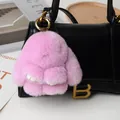 Pink faux fur bunny keychain with golden metal clasp hanging on a stylish handbag - Taro Purple