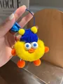 Detail of yellow plush duck keychain with blue knit hat, steel ring and small bell - Yellow