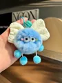 Detail view of a blue furry soot sprite keychain with a white fabric bow. - Blue