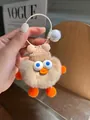 Details eines süßen braunen Plüsch-Enten-Schlüsselanhängers mit Mütze und Glocke - Milchtee-Farbe