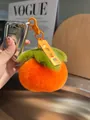 Dettaglio di un portachiavi a forma di cachi in peluche con pelliccia e etichetta creativa - Felicità Eterna