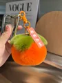 Dettaglio portachiavi a forma di cachi in peluche con pelliccia sintetica e foglia verde - Cachi